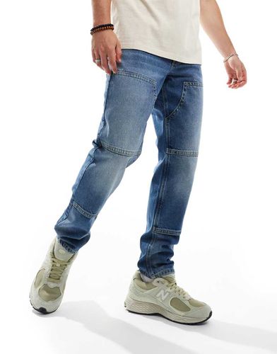 Jeans affusolati lavaggio medio con dettagli stile carpenter - ASOS DESIGN - Modalova