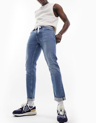 Jeans slim elasticizzati in denim con cimosa lavaggio medio - ASOS DESIGN - Modalova