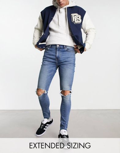 Jeans spray on power stretch lavaggio medio con strappi alle ginocchia - ASOS DESIGN - Modalova