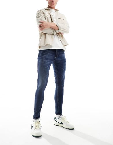 Jeans spray power-stretch lavaggio scuro - ASOS DESIGN - Modalova