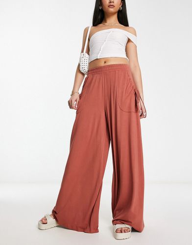 Pantaloni a fondo ampio color ruggine con tasche e vita arricciata - ASOS DESIGN - Modalova