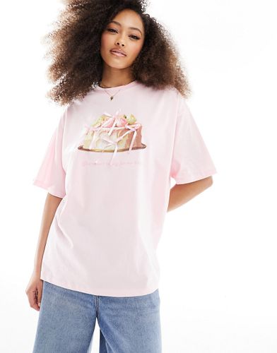 T-shirt oversize con fiocchi in raso e grafica con torta - ASOS DESIGN - Modalova