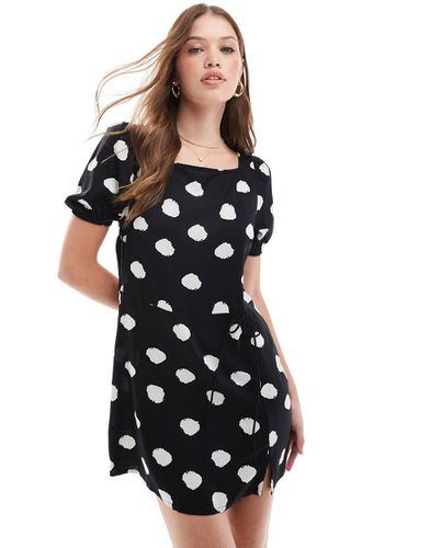 Vestito t-shirt corto a pois monocromatici con maniche a sbuffo e vita avvolgente con laccio - ASOS DESIGN - Modalova