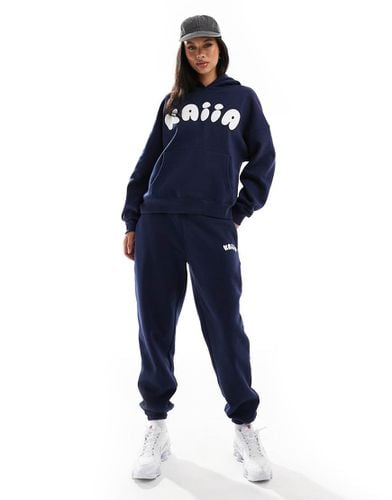 Joggers stretti in fondo con logo in rilievo in coordinato - Kaiia - Modalova