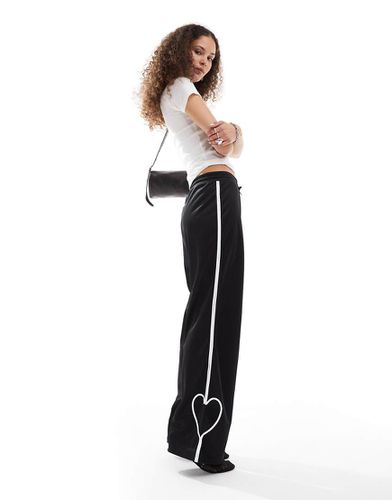 Pantaloni sportivi dritti neri con righe bianche e cuori - Monki - Modalova