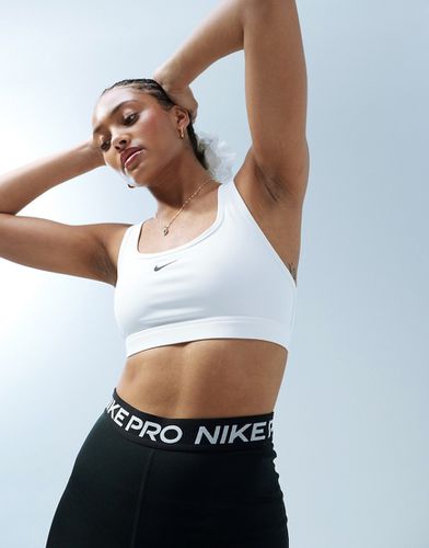 Reggiseno sportivo a sostegno leggero con logo - Nike Training - Modalova