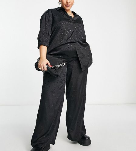 Pantaloni a fondo ampio in raso neri con stampa di stelle in coordinato - Simply Be - Modalova