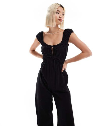 Tuta jumpsuit nera testurizzata allacciata sul davanti - Reclaimed Vintage - Modalova