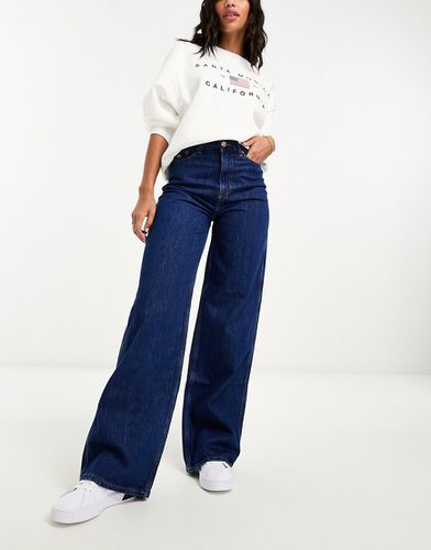 Claire - Jeans a vita alta a fondo ampio lavaggio scuro con logo laterale - Tommy Jeans - Modalova