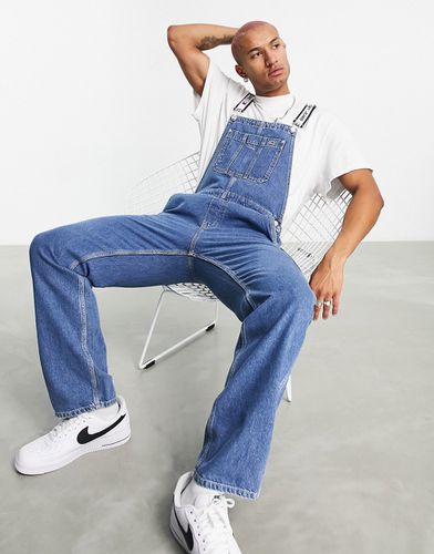 Salopette di jeans ampia con logo lavaggio medio - Tommy Jeans - Modalova