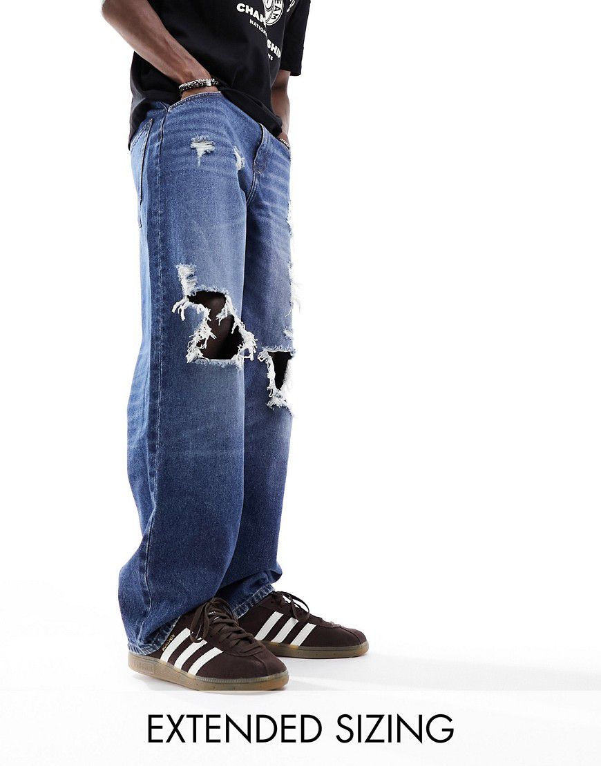Jeans ampi lavaggio medio con strappi vistosi - ASOS DESIGN - Modalova