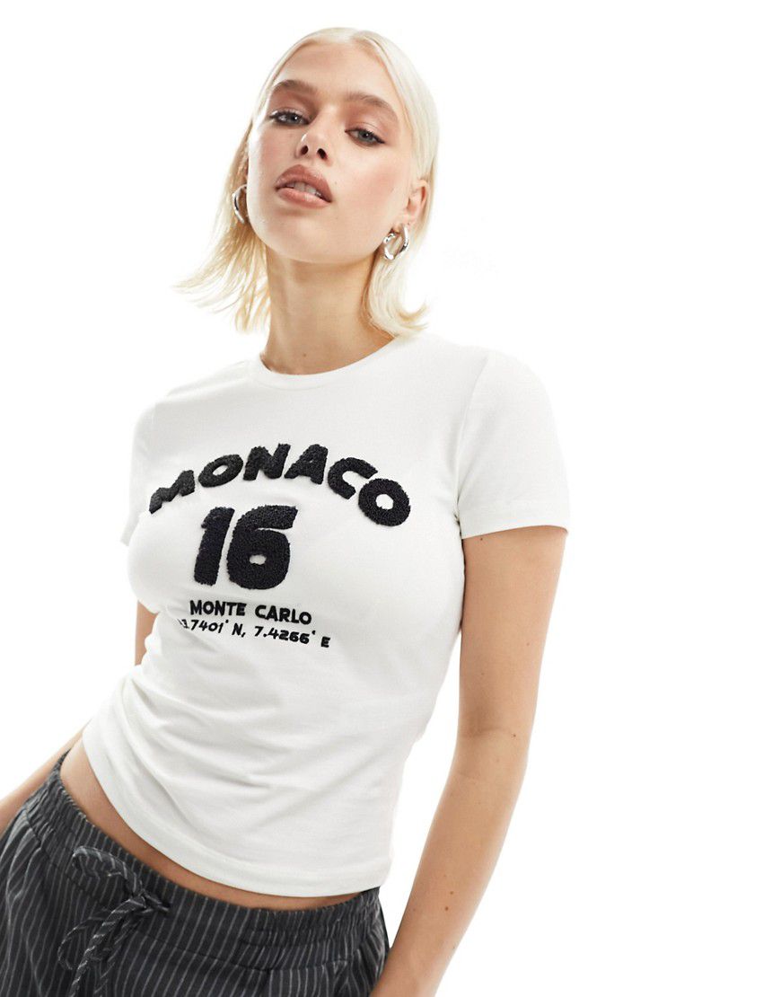 T-shirt baby color crema con scritta Monaco in ciniglia - ASOS DESIGN - Modalova