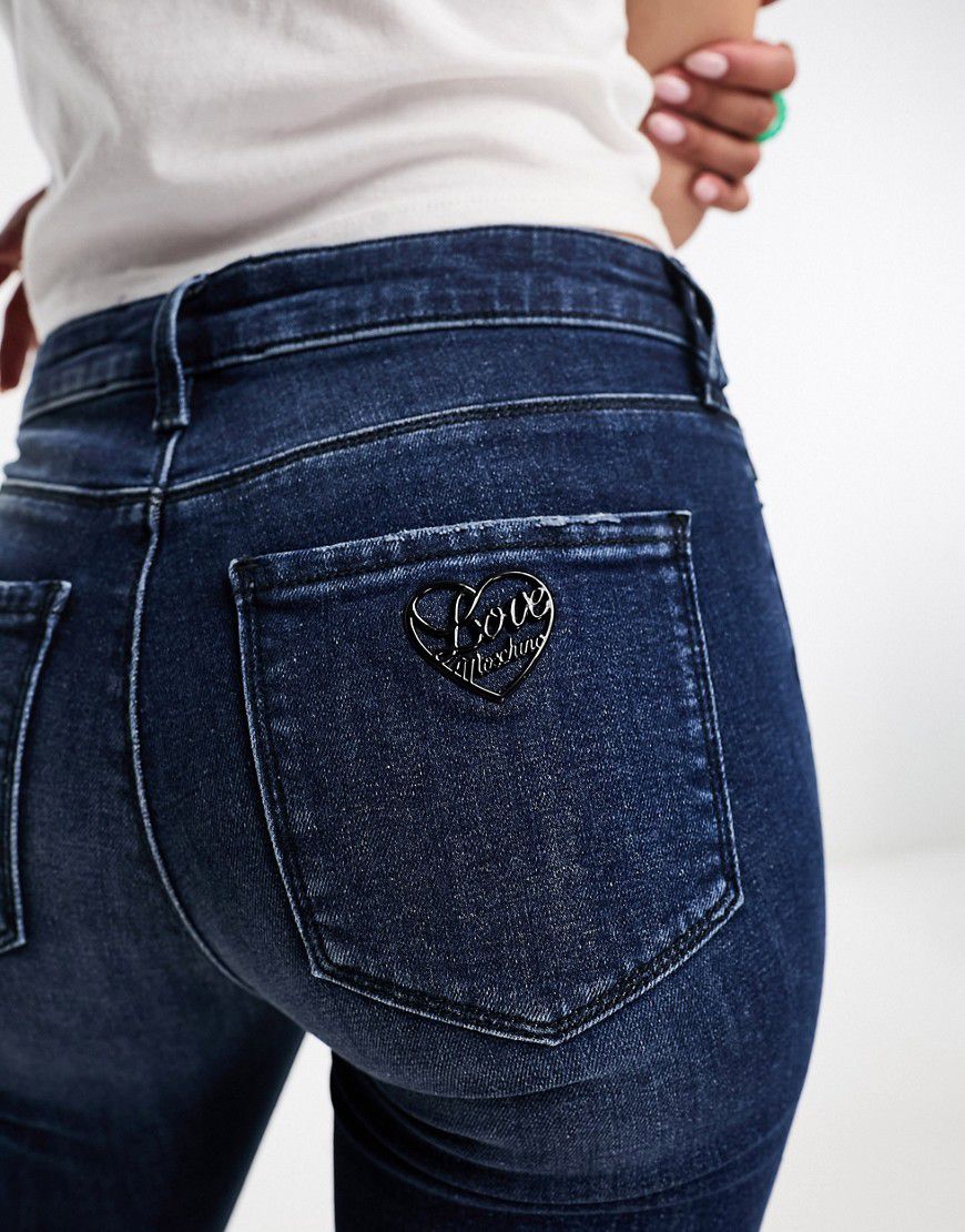 Jeans skinny con logo in strass - Love Moschino - Modalova