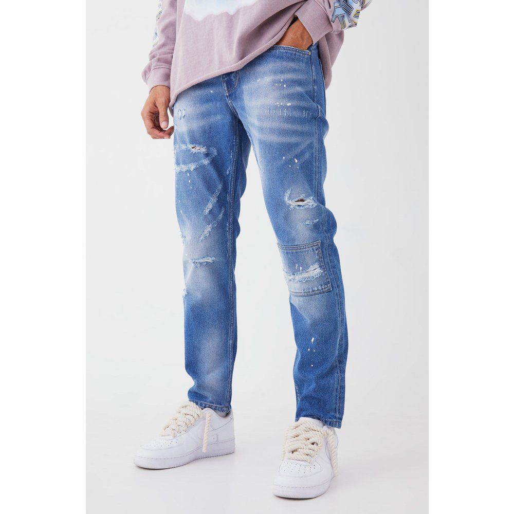 Jeans Slim Fit in denim rigido con strappi sul ginocchio e dettagli dipinti all over - boohoo - Modalova